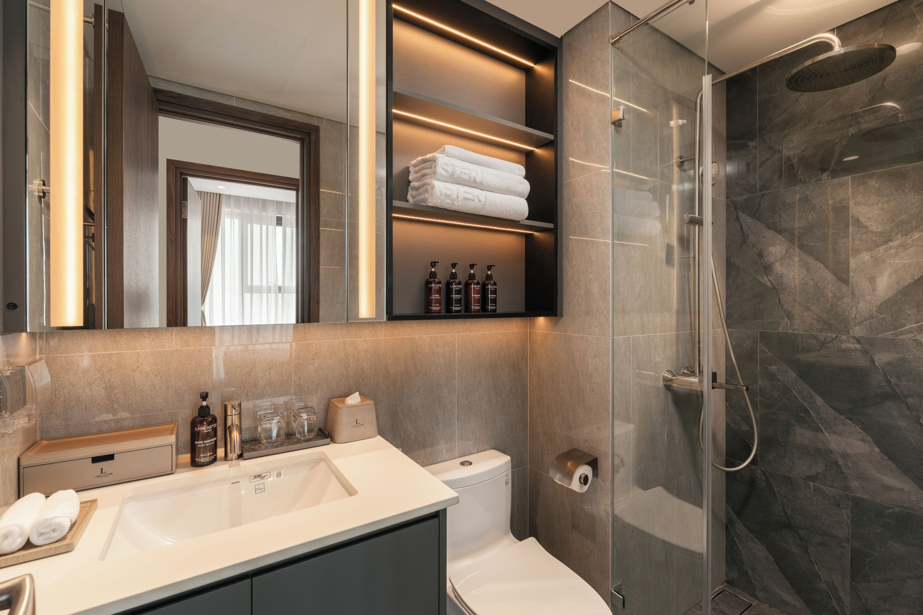 A modern bathroom with a glass shower enclosure, a vanity with a sink, and a toilet.