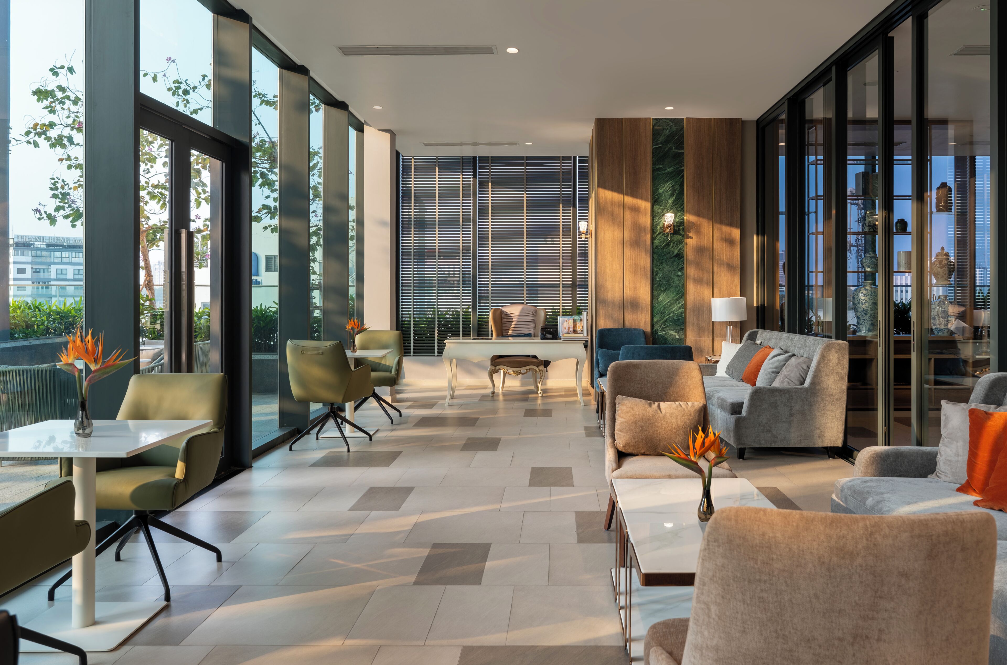 A modern interior with a seating area, a dining table, and a view through large windows.