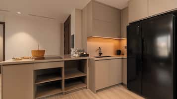 A modern kitchen with a black refrigerator, built-in cabinets, and a light-colored countertop.