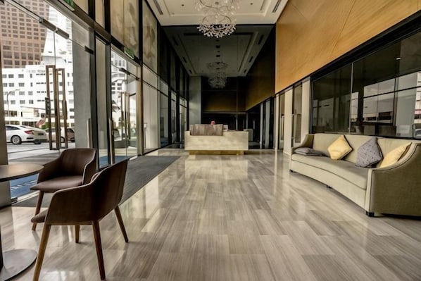Eine moderne Lobby mit einer Couch, Sesseln und einer Treppe.