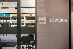 Blick durch ein Fenster eines GebÀudes, auf dem die Schilder 'TOWER A' und 'IMPERIO RONDO NERI' zu sehen sind.
