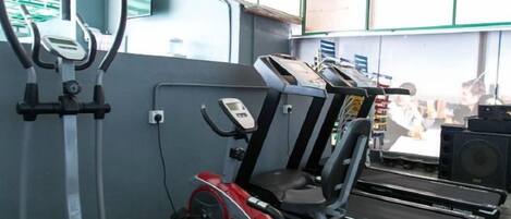 A gym with exercise equipment including treadmills, a stationary bike, and a rowing machine.