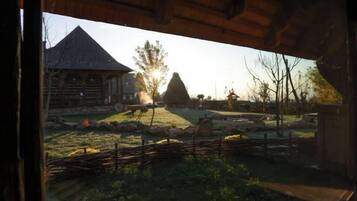 A rustic wooden structure with a view of a traditional building and a fenced yard.
