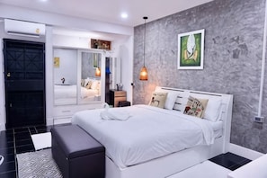 A modern bedroom with a bed, bedside table, and a large mirror.