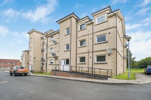 A multi-story residential building with satellite dishes, a staircase, and a gated entrance. - Premier - Clydesdale Apartment (North Lanarkshire)