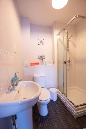 A bathroom with a sink, toilet, and shower.