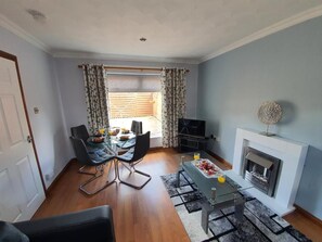 A living room with a dining area, a fireplace, and a television.