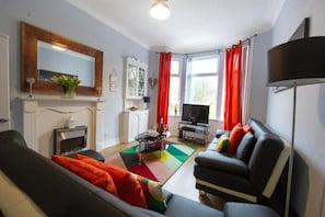 A living room with a fireplace, a television, and a sofa.
