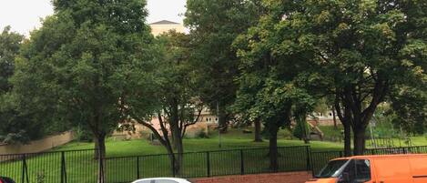 A parking area with cars and a fence.