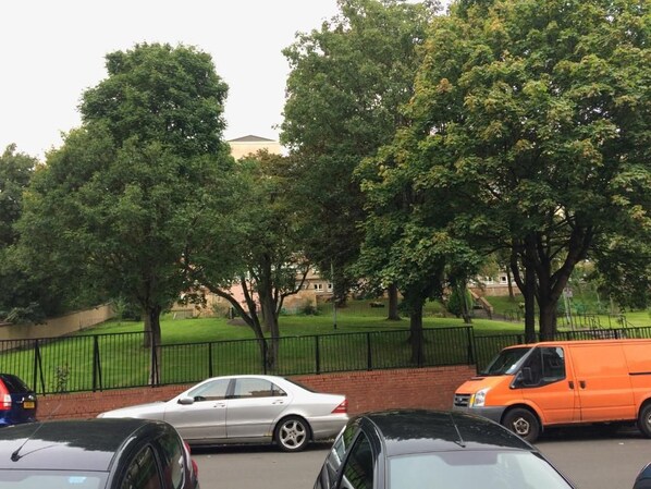 A parking area with cars and a fence.