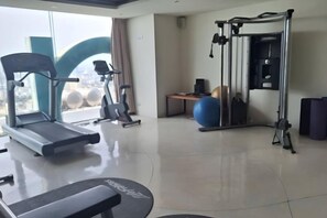 A gym with treadmills, a weight machine, and a blue exercise ball. - Aparthotel in A La Carte - 2 bedrooms, balcony, beachfront, rooftop pool, central (Da Nang)
