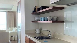 Een moderne keuken met een ingebouwde oven, een spoelbak en houten planken boven het aanrecht.