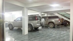 Ett parkeringsgarage med två stora terrängbilar och en motorcykel.