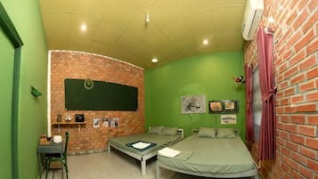 A room with a brick wall, a bed, a desk, and a chair.