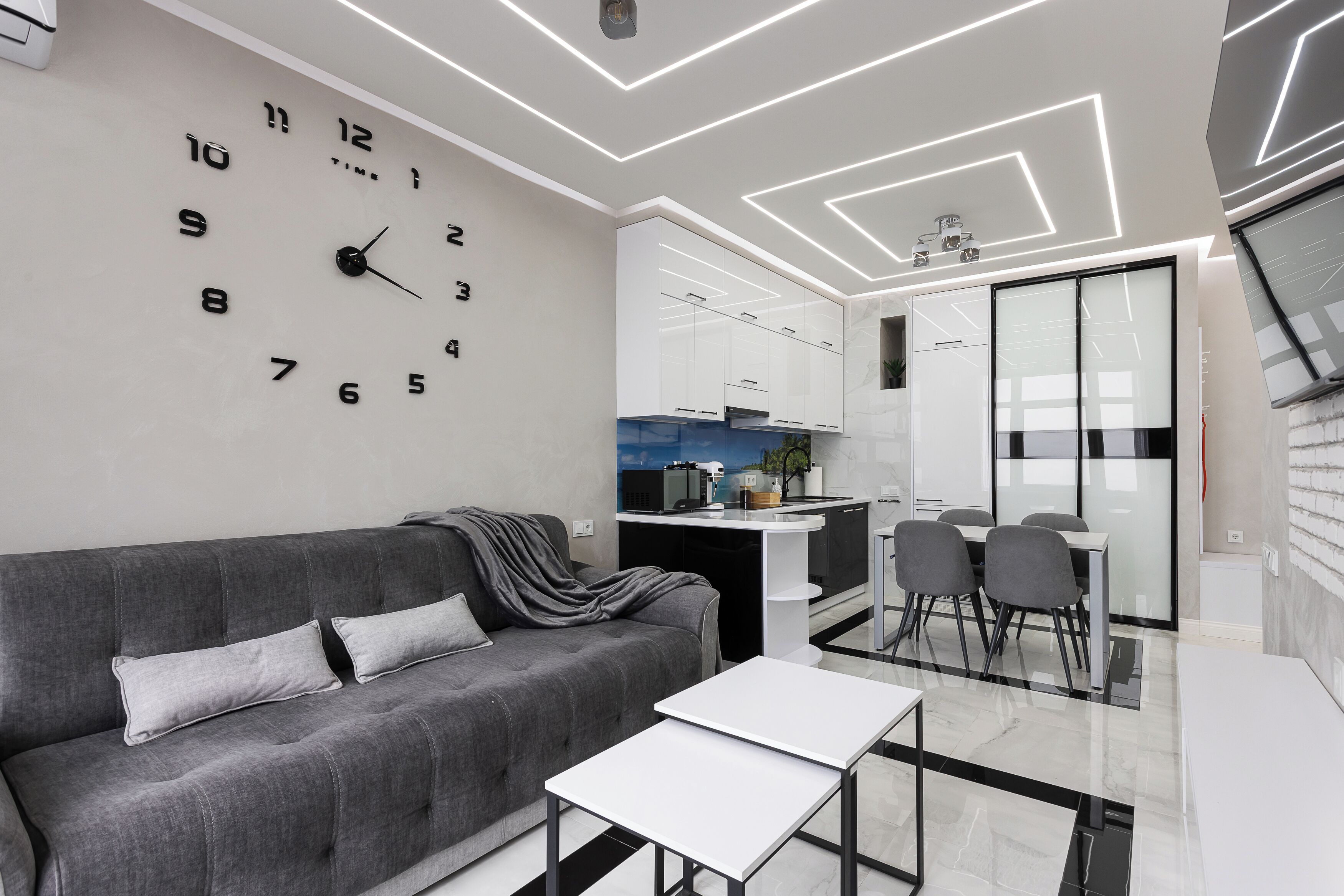 Een moderne woonkamer met een bank, een salontafel en een wandklok.