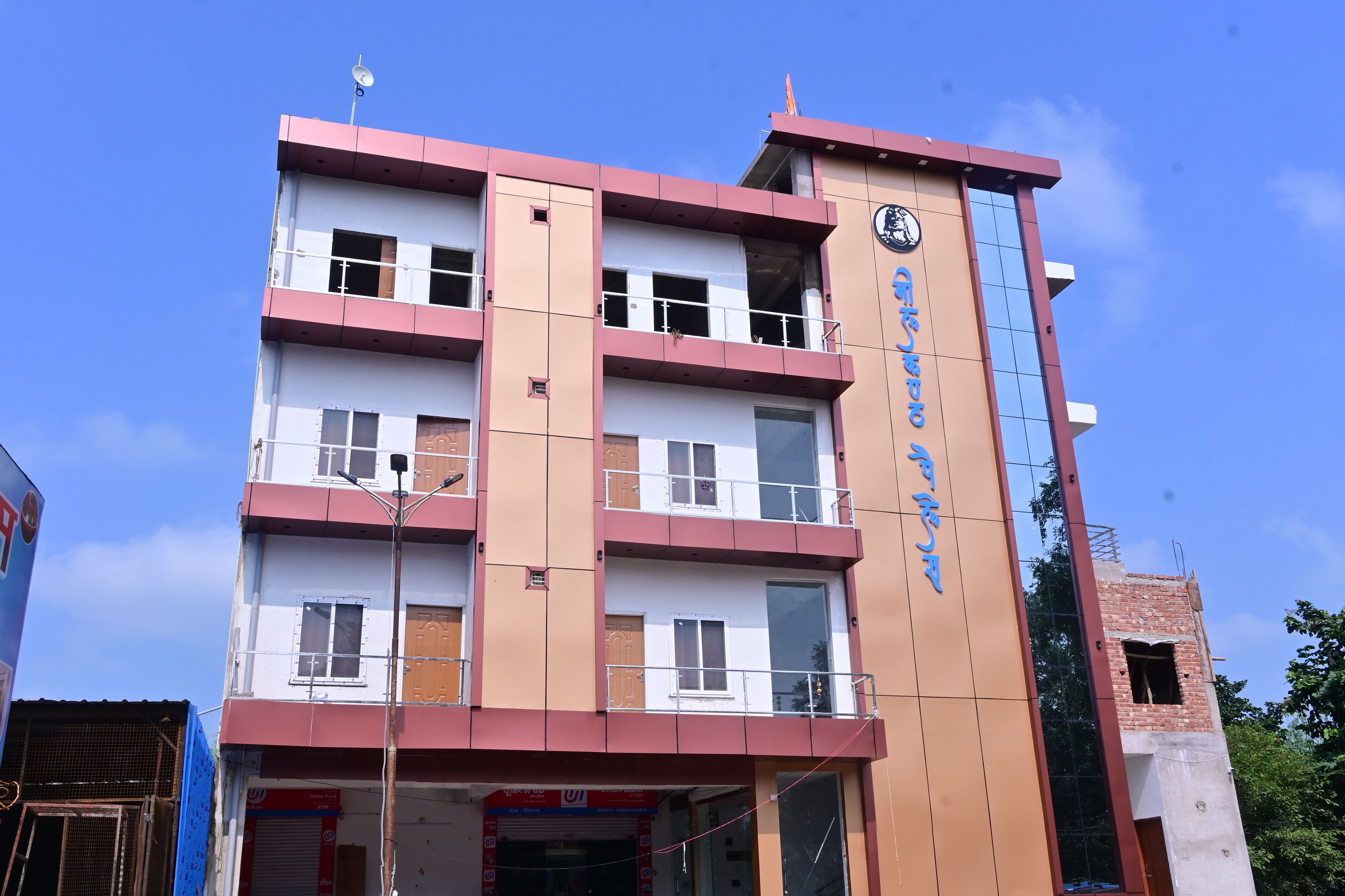 A multi-story building with a prominent clock tower, a sign with foreign script, and a visible ATM on the ground floor.