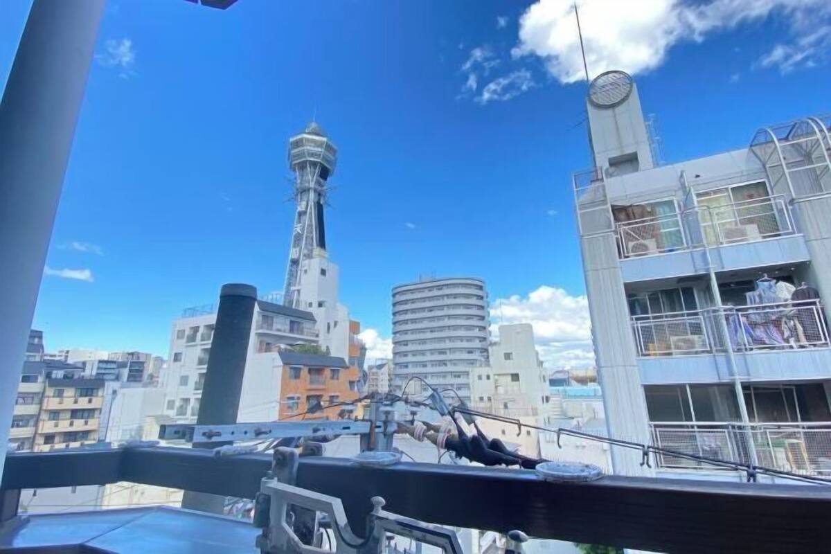 Vista de un paisaje urbano con edificios modernos, incluyendo una torre alta y una estructura cilíndrica.
