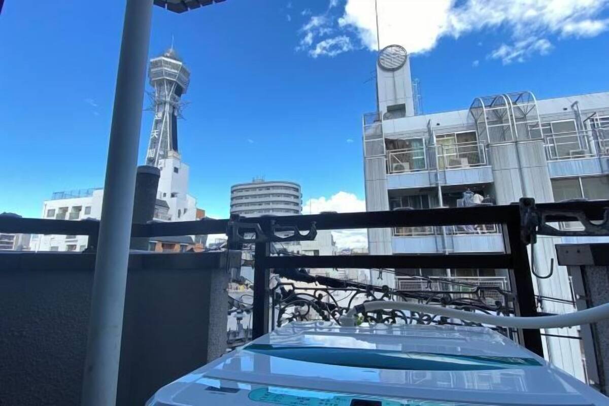 Un edificio moderno con fachada de vidrio, una torre del reloj y una estructura circular al fondo.