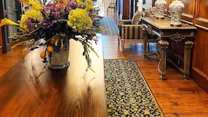 A hotel lobby with a wooden reception desk, a chandelier, and a floral arrangement. - P.A. Smith Hotel (Navasota)