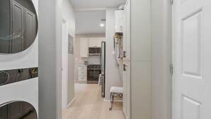 Eine moderne Küche mit weißen Schränken, einem Edelstahlkühlschrank und einem Einbauofen.