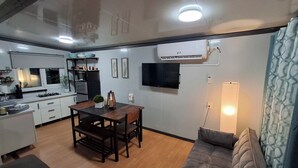 A compact living space with a kitchenette, dining area, and a sofa.