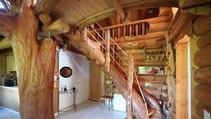 Un interior rústico con una escalera de madera, un comedor y una cocina.