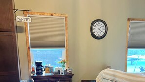 Un rincón comedor acogedor con una mesa redonda, sillas y un reloj en la pared.
