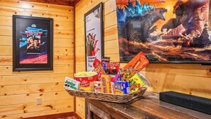 A wooden interior with framed movie posters, a snack basket, and a wooden bench.