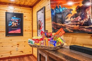 Un interior de madera con carteles de películas enmarcados, una cesta de aperitivos y un banco de madera.