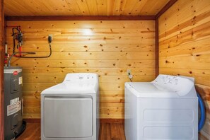 A laundry room with two washing machines and a water heater. - 6-Bedroom Cabin with Indoor Pool, Movie Theater & Hot Tub Near Dollywood (Sevierville)