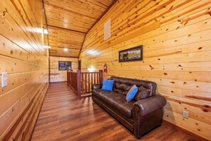 Ein Holzinterieur mit Ledersofa, Holzwänden und Holzboden.