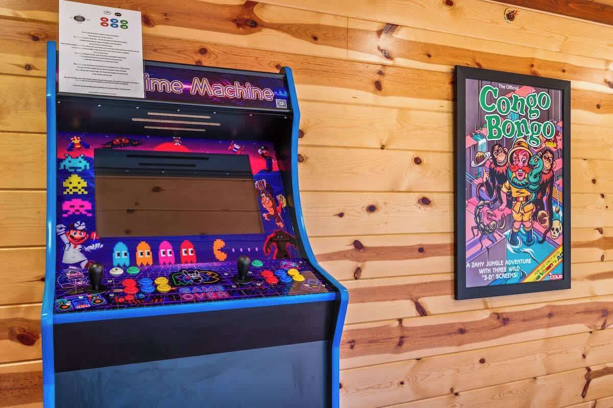Een retro spelcomputer met een scherm waarop spelopties staan, en een ingelijst stripboek aan de muur.