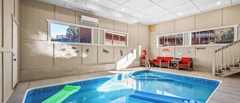 Una piscina interior con vistas a un edificio a través de una ventana.