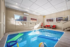 Una piscina interior con vistas a un edificio a través de una ventana.