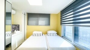 A room with two beds, a mirror, a window with blinds, and a wardrobe. - ABC Homestay Guesthouse (Incheon)