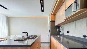 Una cocina moderna con una isla central, armarios de madera y un lavamanos de acero inoxidable.