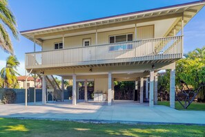 A two-story building with a covered patio area and a balcony.