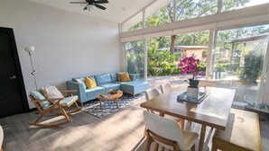 A spacious room with a large dining table, a blue sofa, and a rocking chair. - Surfer`s Oasis Pool Villa The Point Playa Avellana (Playa Avellanas)