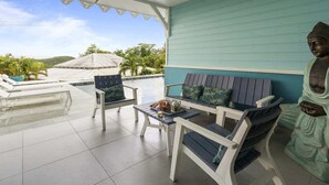 Une terrasse avec une piscine, un espace salon et une statue de Bouddha.