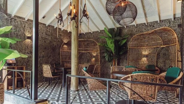 A restaurant with wicker furniture, a patterned floor, and hanging lights. - Cabañas Cielo Verde (Rionegro)