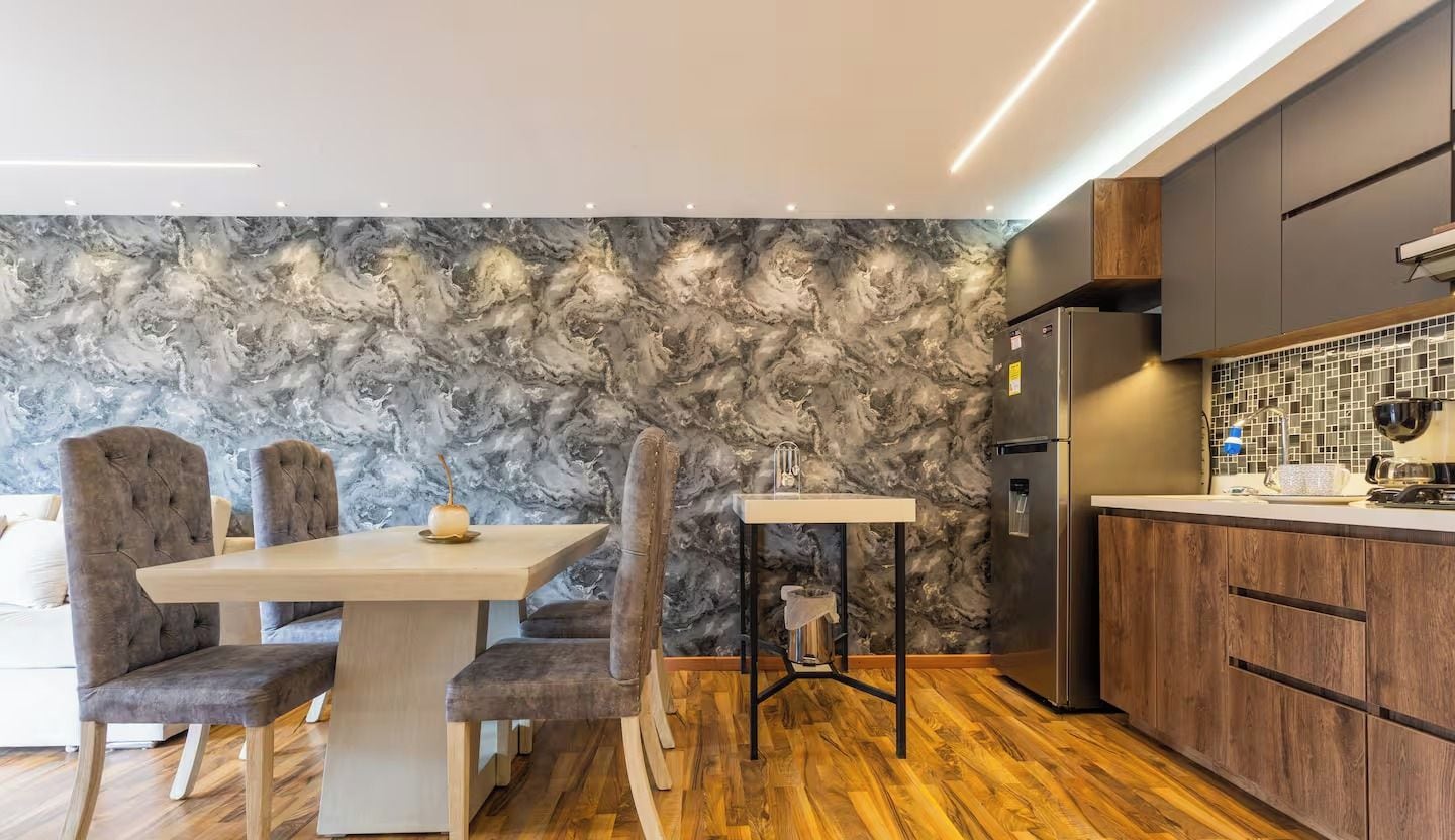 A modern kitchen with a marble backsplash, wooden cabinets, and a built-in refrigerator.