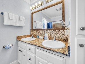 A bathroom with two sinks, a large mirror, and a towel rack. - Knee Deep (Panama City Beach)