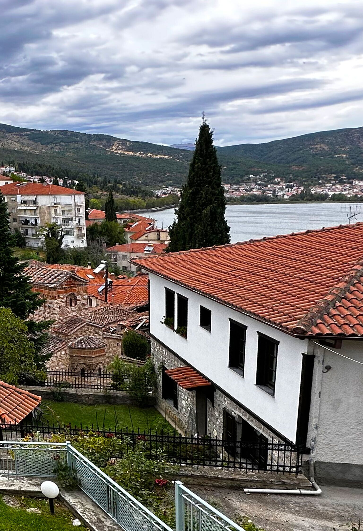 Un pueblo costero con edificios de tejas rojas, una iglesia destacada y vistas al mar.
