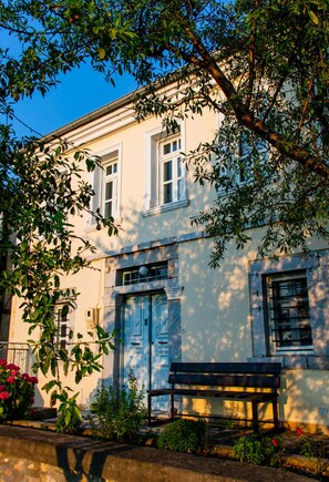 A building with a white facade, a blue door, and a bench in front. - The Dream Villa Kastoria (Kastoria)