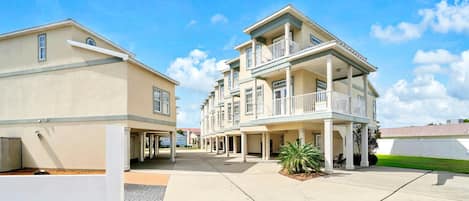 A multi-story residential building with a central courtyard, balconies, and a gated entrance.
