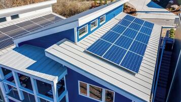 Een modern gebouw met meerdere zonnepanelen op het dak.