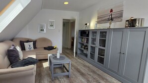 A loft-style living room with a high ceiling, a built-in bookshelf, and a cozy seating area.