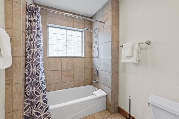 A bathroom with a bathtub, shower, and window. - Fox Den at Emmett Lode (Breckenridge)