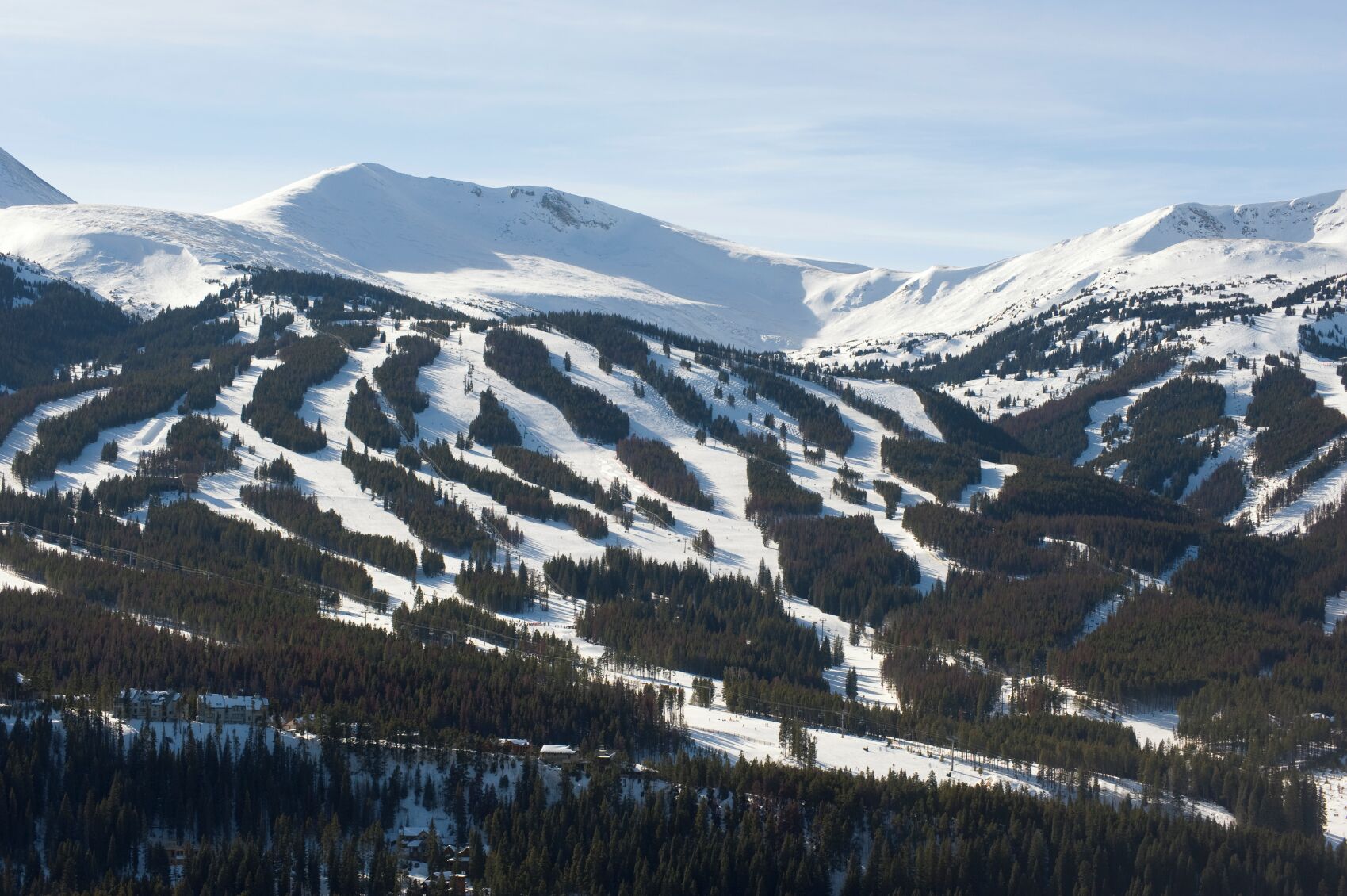A mountainous landscape with snow-covered slopes and a ski resort.