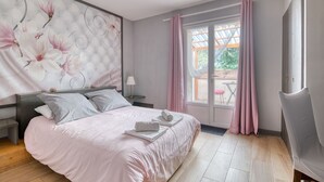 A bedroom with a bed, a nightstand, a chair, a window with curtains, and a view of the outside. - Bed and Breakfast 'La Des Lys' with Shared Pool, Shared Garden and Wi-Fi (Le Fraysse)